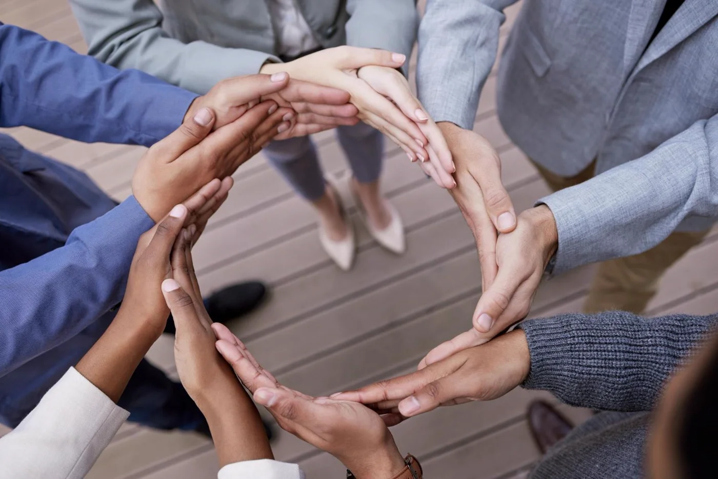 A circle of hands joined together in the centre — leaders standing in shared commitment